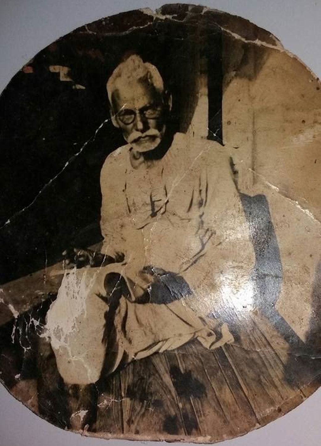A cracked, faded sepia print of an elderly man, as it was found.